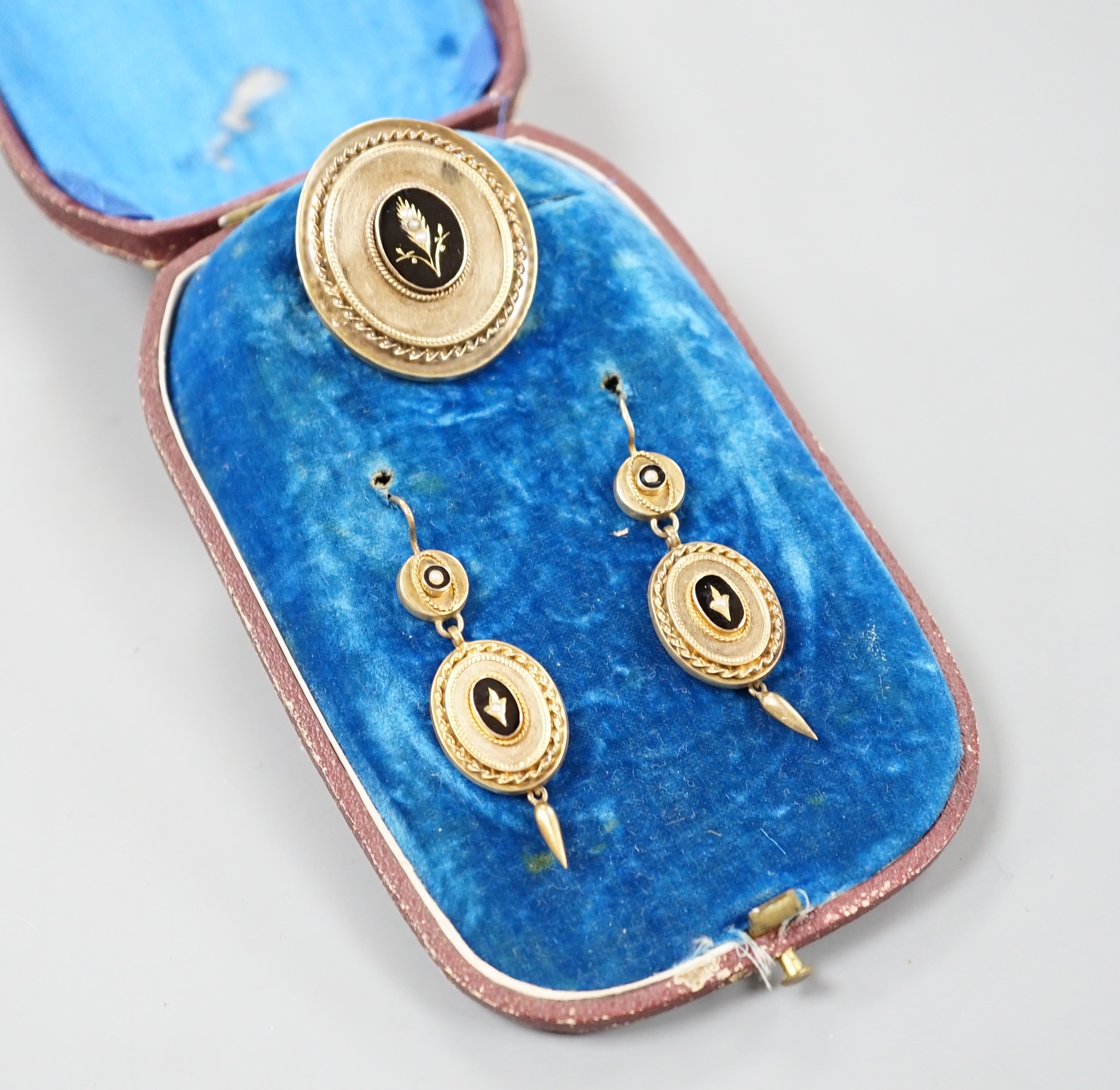 A cased Victorian yellow metal, black enamel and seed pearl set brooch, 35mm and matching pair of drop earrings, gross 13.6 grams.